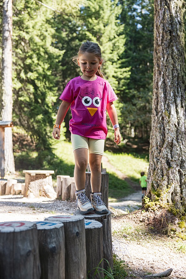 Bambina lungo il sentiero di Frainus tra gioco e movimento nel bosco